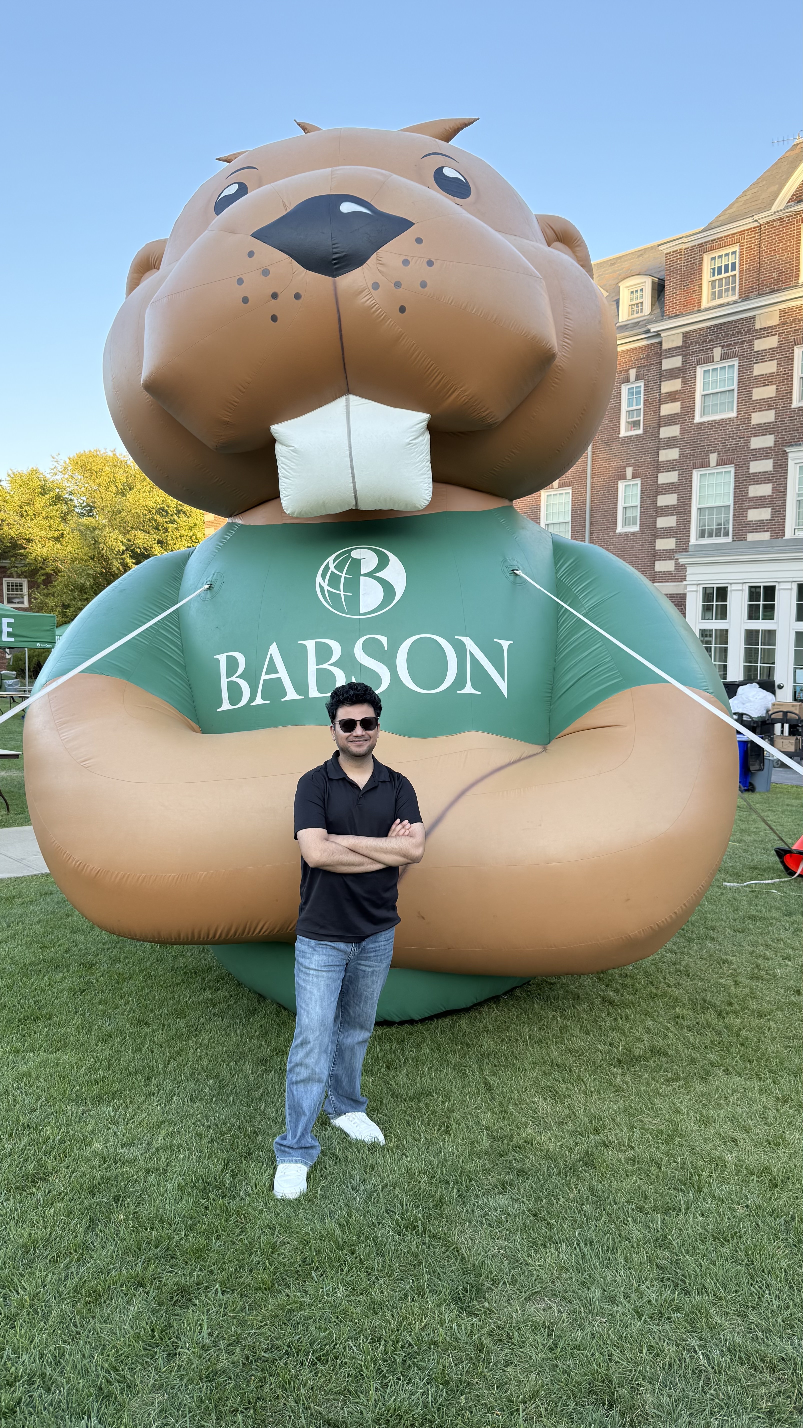 Person posing in front of the giant Babson College inflatable beaver mascot