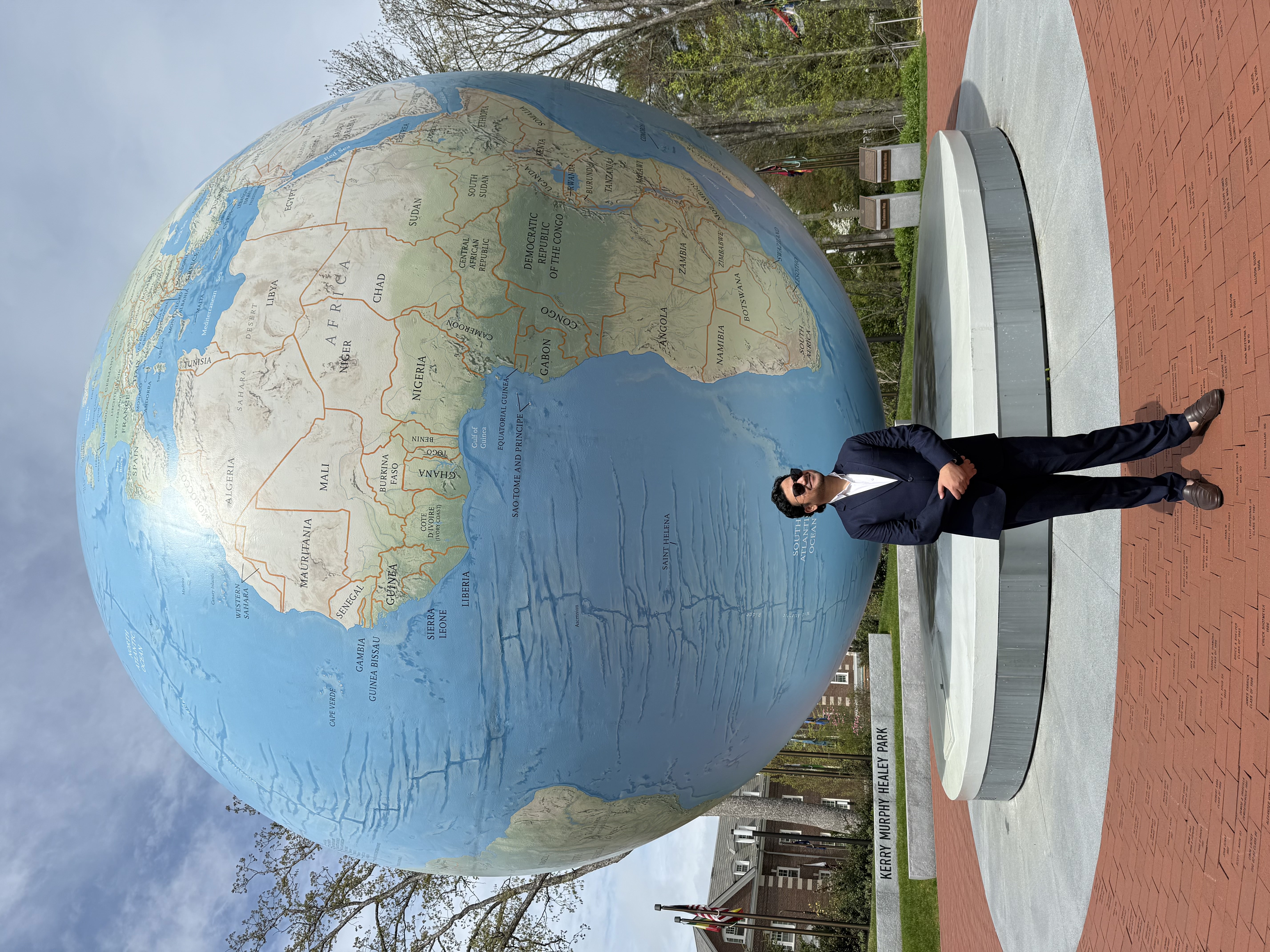 Person in a suit standing in front of the iconic Babson globe sculpture