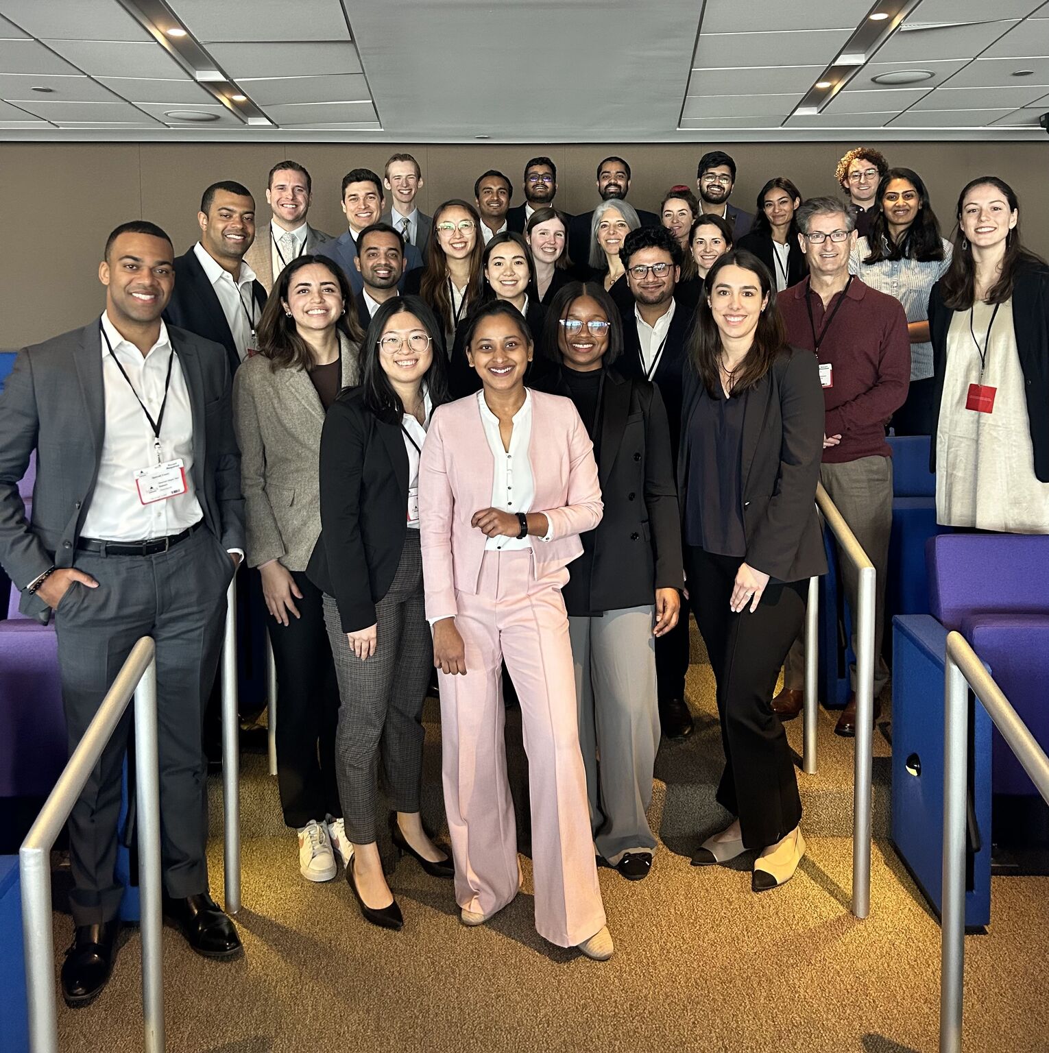 Large group of MBA students in business attire at a case competition venue