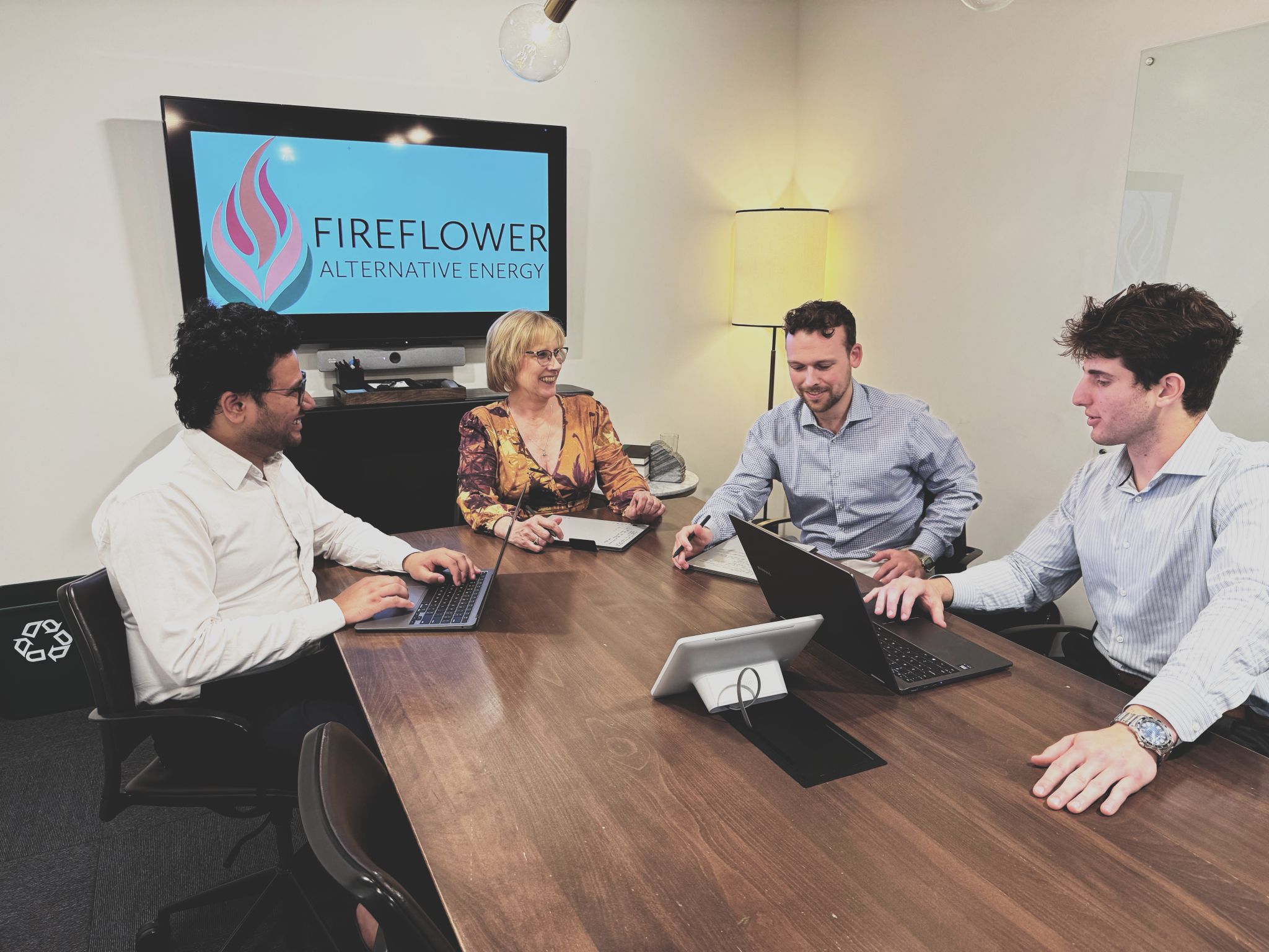 Four people in a working meeting at Fireflower Alternative Energy office